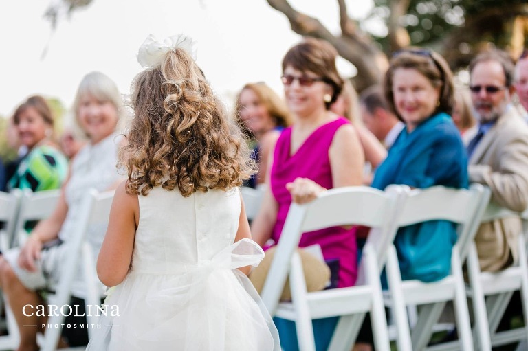 All eyes are on the adorable flower girl as she warms up the aisle for the bride. © Carolina Photosmith