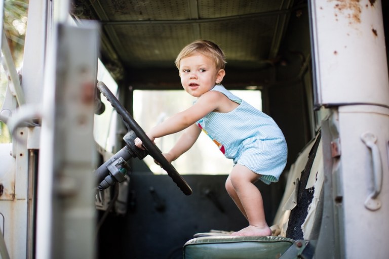 Toddler dreams big on huge vintage truck.