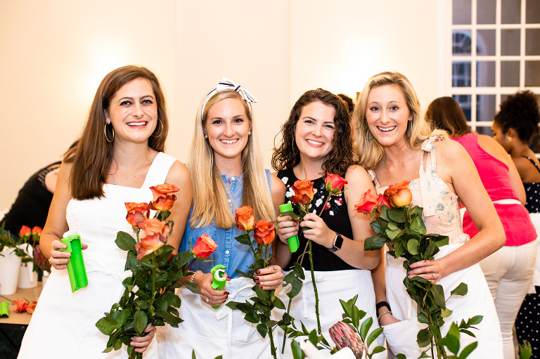 Charleston Flower Social attendees design floral arrangements with roses.